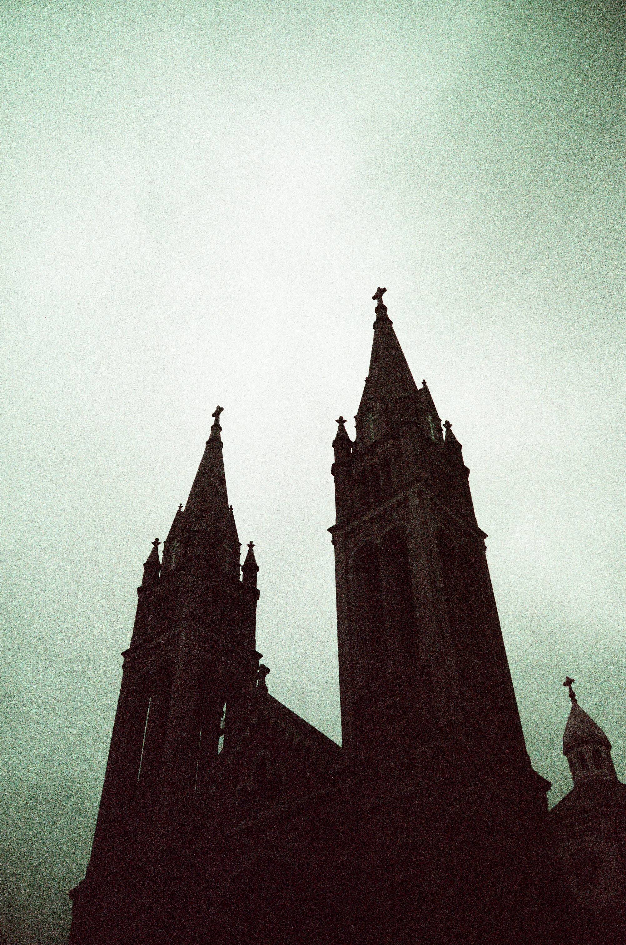 Looking up a two church spires and the sky is and church are weird shifted purplish colors
