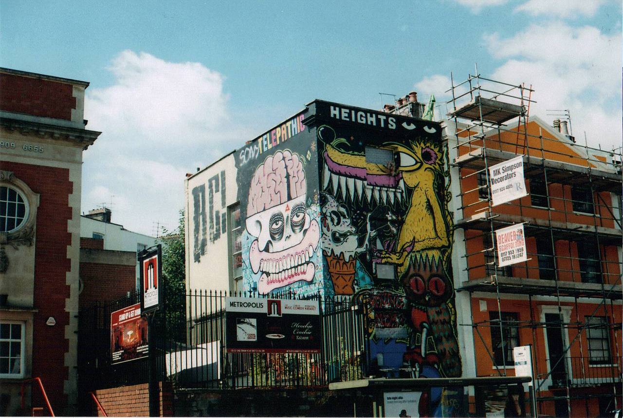斯托克斯克罗夫特街区（Stokes Croft） 常被称作布里斯托尔的 “文化街区”。这里热闹喧嚣、充满原始张力与活力 —— 壁画、涂鸦与 DIY 街头装置艺术，让这里成为街头摄影的绝佳地点。你可以在这里找到地道小店、优质酒吧、特色俱乐部、美味佳肴，以及众多艺术家工作室与常换常新的展览。使用 LomoChrome Purple 紫调负片拍摄，为画面增添一抹鲜艳色彩 吧！Photo by @jigsaw