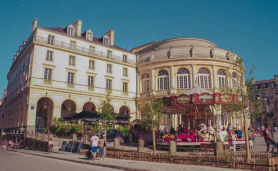 在雷恩市中心 雷恩圣安妮广场 (Place Sainte-Anne, Rennes)e 是个很热闹的地方，周围是历史建筑和传统的老石墙，很有味道。广场以圣安妮教堂为中心，两侧开着咖啡馆、旧书摊，还有一座复古的旋转木马。早上可以在这儿端杯咖啡，看着城市慢慢醒过来，再出发去逛。用 Sprocket Rocket 齿孔火箭 135 胶片相机拍一张长曝光的全景，把人群流动的轨迹也收进画面里。(Photo by the_big_meowski )